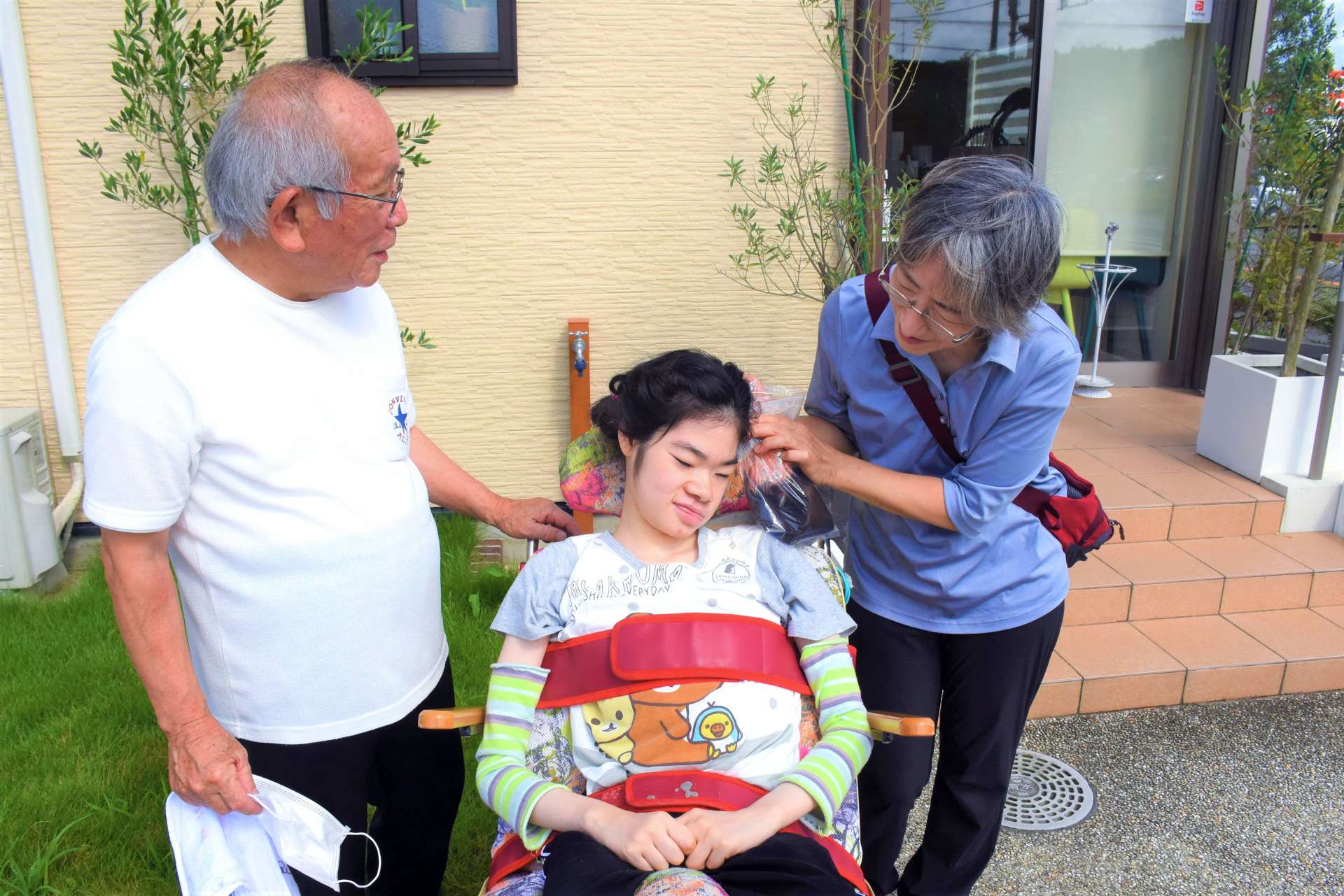 田中茜さん（中央）にカットした髪を見せる絹子さん（右）と洋海さん