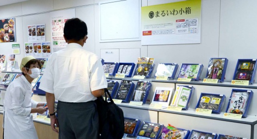 販売員の助言を受けながら地元の特産品を選ぶ客=鹿児島市金生町の山形屋
