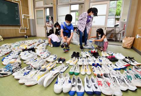 寄付されたシューズを教室に並べる子どもたち＝鹿児島市古里町