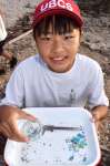 拾い集めたマイクロプラスチックの瓶詰めを手にする竿りりさん