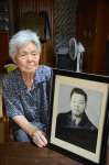 空襲で亡くなった父・信一さんの遺影と川田満子さん＝姶良市脇元