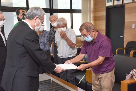 朝山毅市長（左）に滝名の公募中止を求める小湊集落の住民＝１７日、奄美市役所