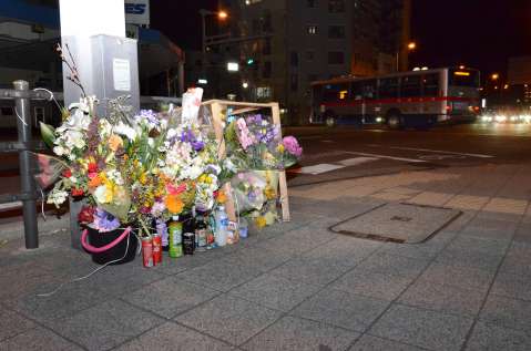 大学生がはねられ死亡した現場に手向けられた花束や飲み物＝鹿児島市大竜町