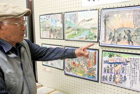 自作の絵を通じて空襲体験を伝える野崎恭弘さん。「怖かった記憶は薄れない」と話す＝日置市東市来