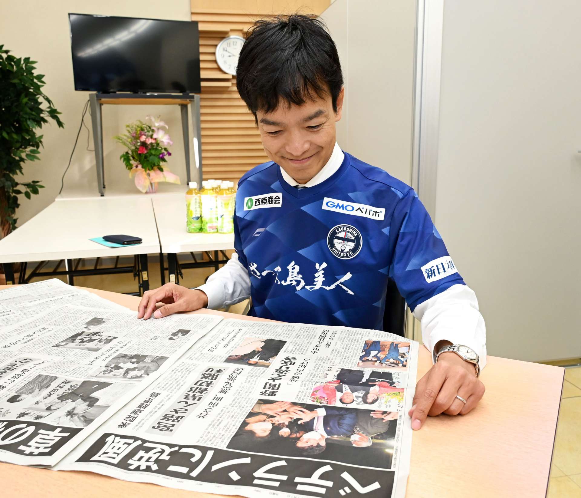一夜明け、当選を伝える新聞に目を通す宮路拓馬さん＝１日、鹿児島市上之園町
