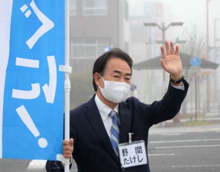 通行人に手を振る野間健さん＝１日、薩摩川内市西向田町