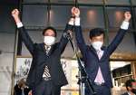 当選後、手を取り合って拳を突き上げる宮路拓馬氏（右）と保岡宏武氏＝１日、鹿児島市上之園町