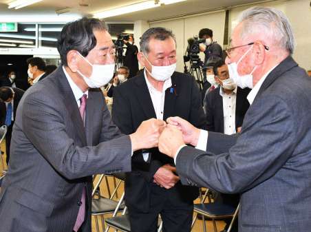支援者をグータッチでねぎらう金子万寿夫さん＝１０月３１日、鹿児島市谷山中央４丁目