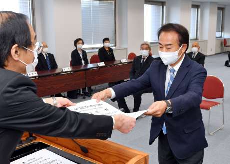 神妙な面持ちで当選証書を受け取る野間健氏＝３日、鹿児島県庁