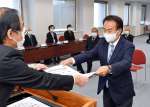 神妙な面持ちで当選証書を受け取る野間健氏＝３日、鹿児島県庁