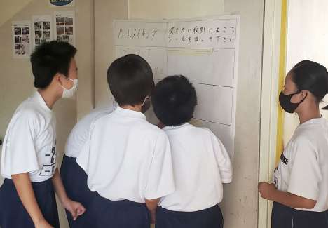 変更を希望する校則にシールを貼る生徒たち＝鹿児島市の鴨池中学校（提供）