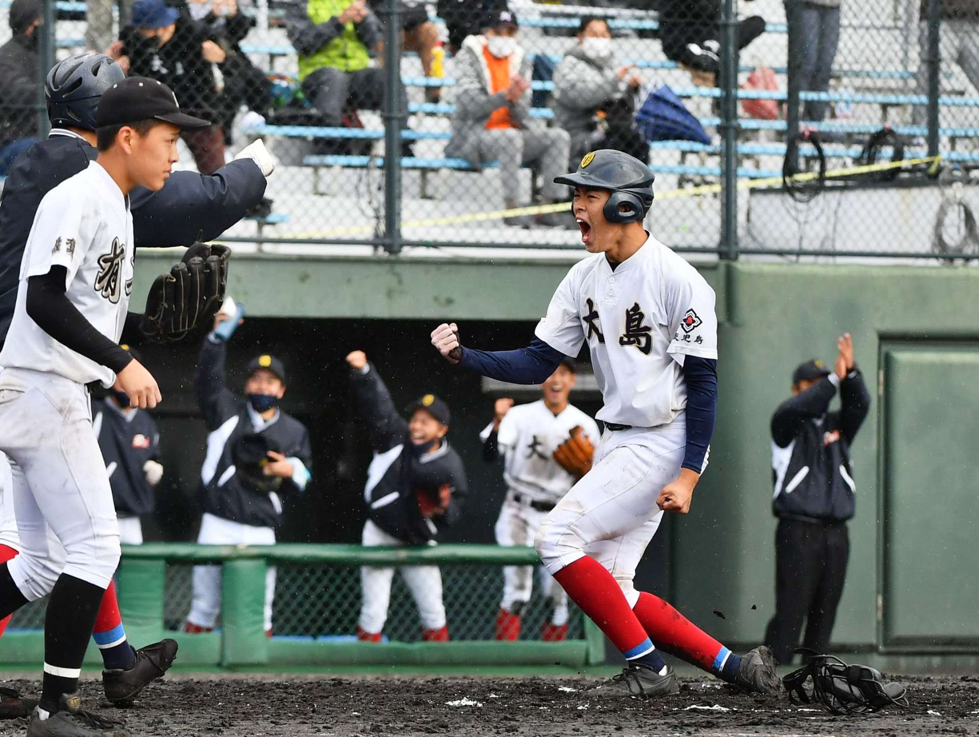 ９点目のホームを踏み、ガッツポーズする大島の西田心太朗選手＝１１日、鹿児島市の平和リース球場