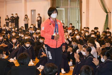 後輩たちに拍手で迎えられる浜田尚里選手＝霧島市の国分南中学校