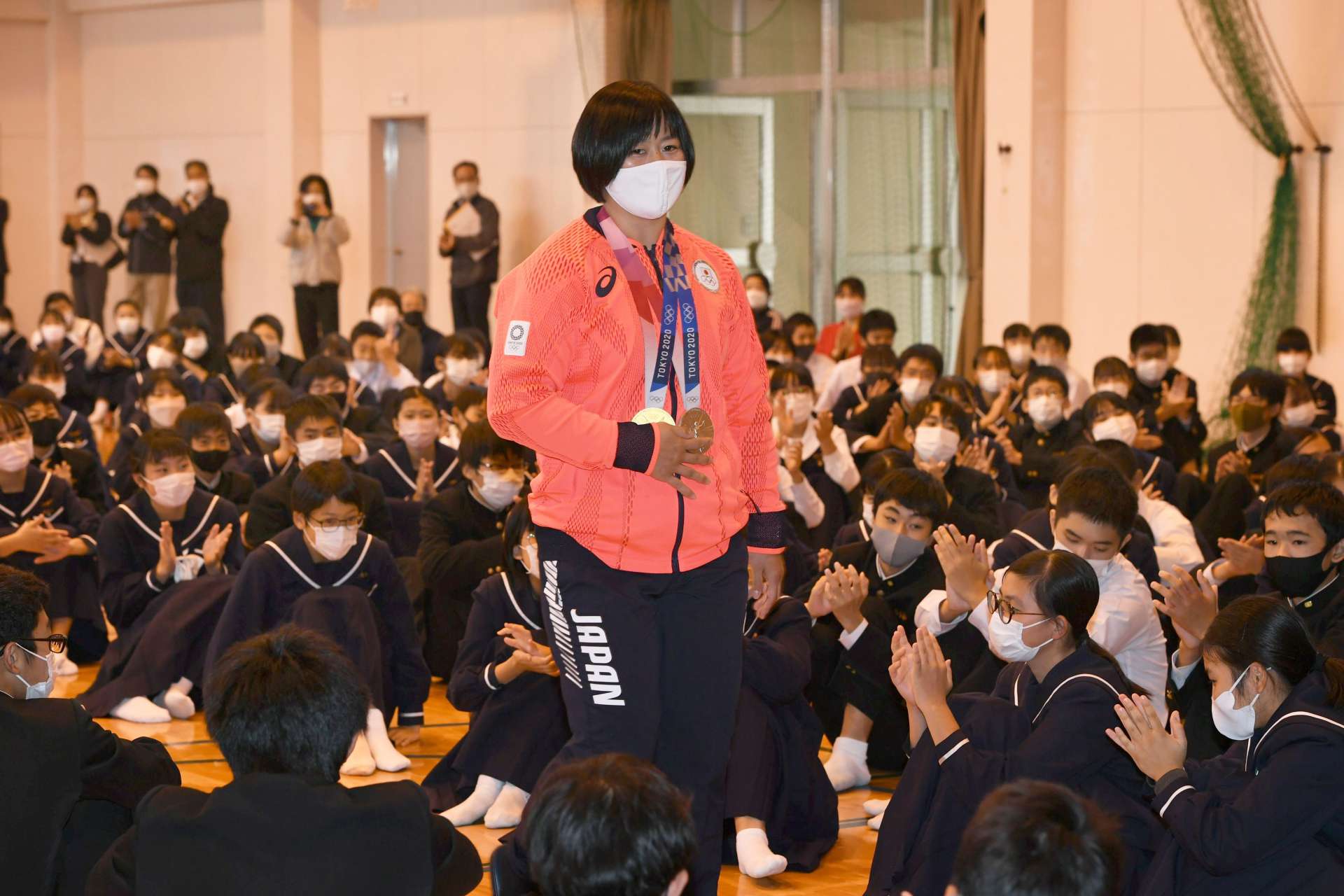 後輩たちに拍手で迎えられる浜田尚里選手＝霧島市の国分南中学校