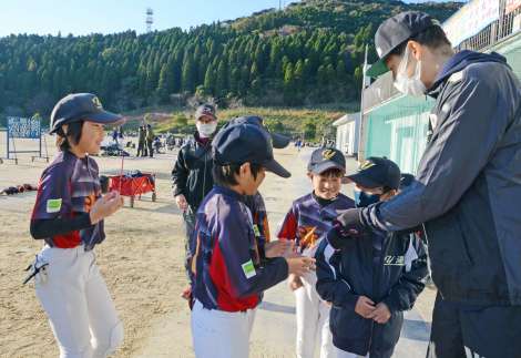 子どもたちと握手して交流する横田慎太郎さん＝日置市東市来総合運動公園