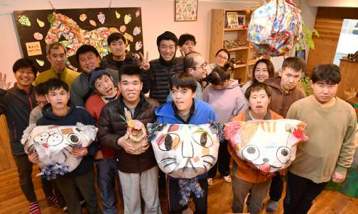 作品を手に、笑顔の利用者ら＝鹿児島市皆与志町のぎゃらりーＡＳＡＨＩＹＡ