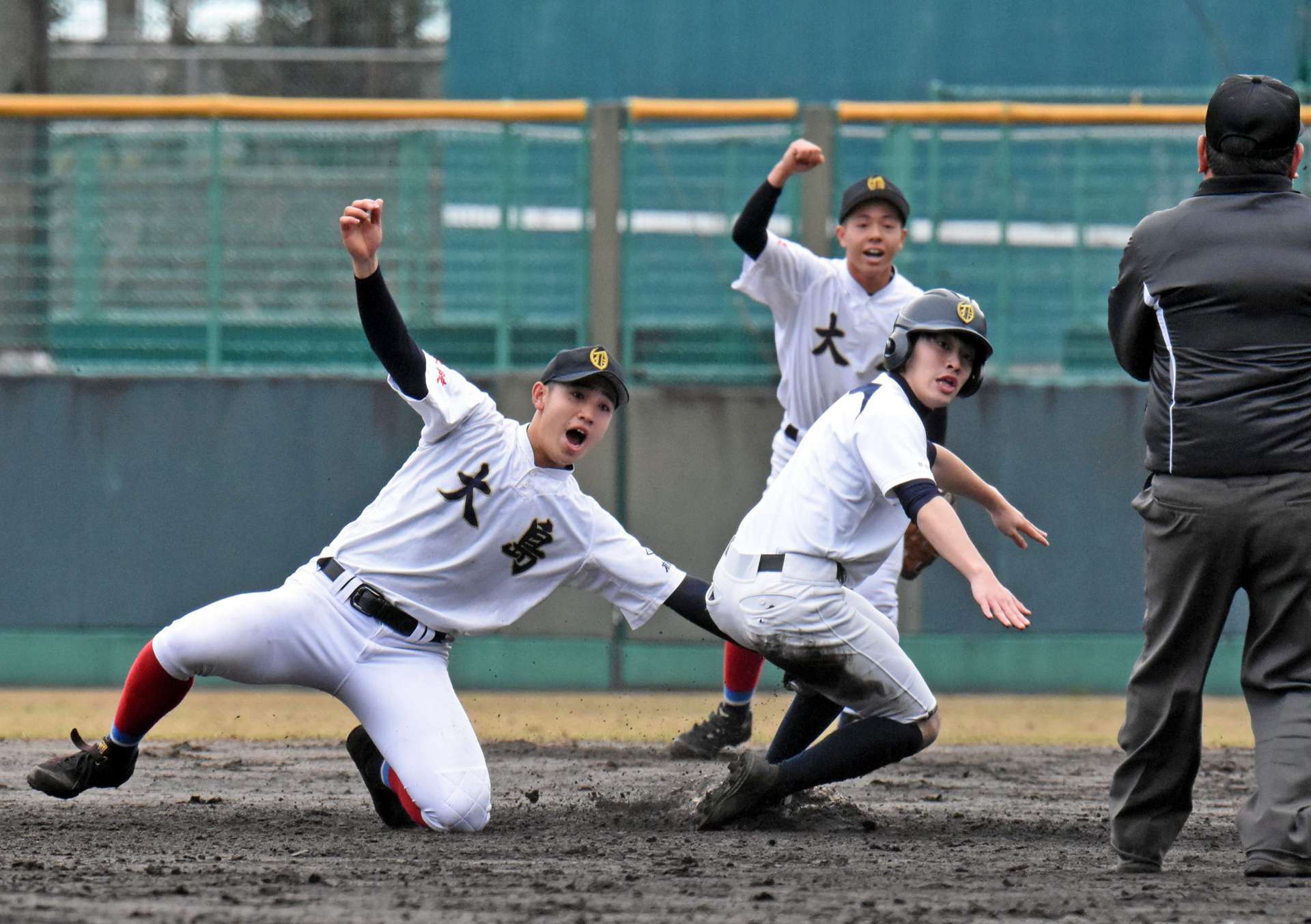 熱戦を繰り広げる大島高校野球部の現役チーム（左）とＯＢチーム＝２日、奄美市名瀬