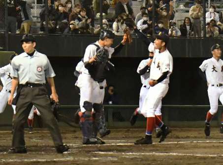 ハイタッチで勝利を喜ぶ大島の大野稼頭央選手（右）と西田心太朗選手＝２０２１年１１月７日、鹿児島市の平和リース球場