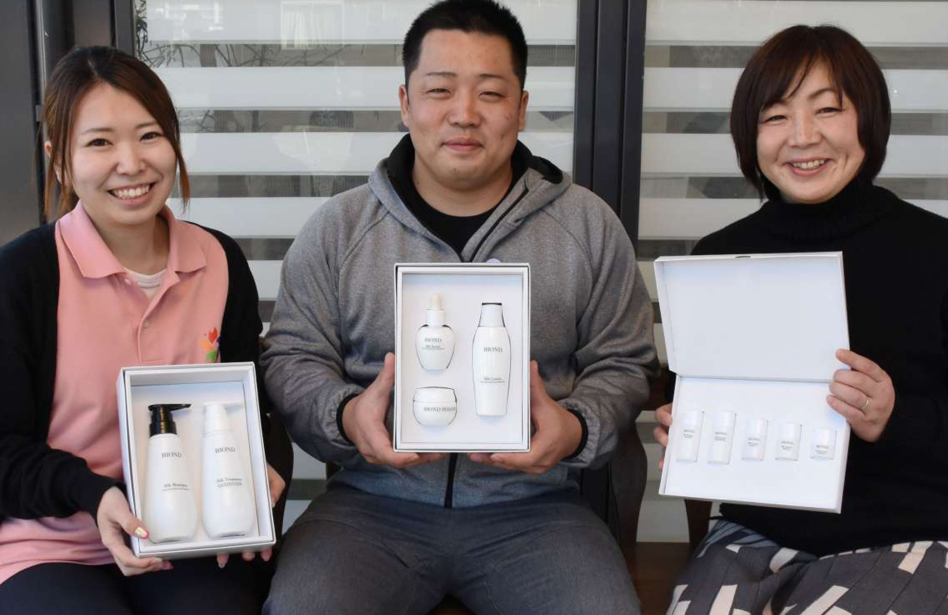 シルクで作った化粧品を持つ植村頼美さん（右）とスタッフ＝薩摩川内市都町