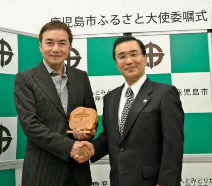 2011年11月、鹿児島市のふるさと大使に委嘱され、森博幸市長（右、当時）と握手する西郷輝彦さん＝鹿児島市役所