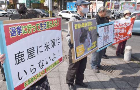 プラカードを持ち戦争反対を訴える市民＝５日、鹿屋市