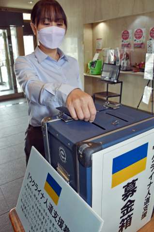 募金箱に寄付金を入れる市民＝１０日、鹿屋市役所