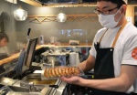 焼き上げたギョーザを持ち帰り用に手早く詰める店員＝鹿児島市武１丁目