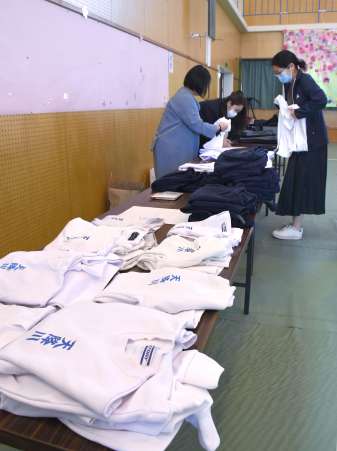 集まった体操服などを整理する保護者ら＝霧島市国分福島１丁目の天降川小学校