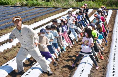 ＵＳＡさんを手本に踊りながら種をまく子どもたち
