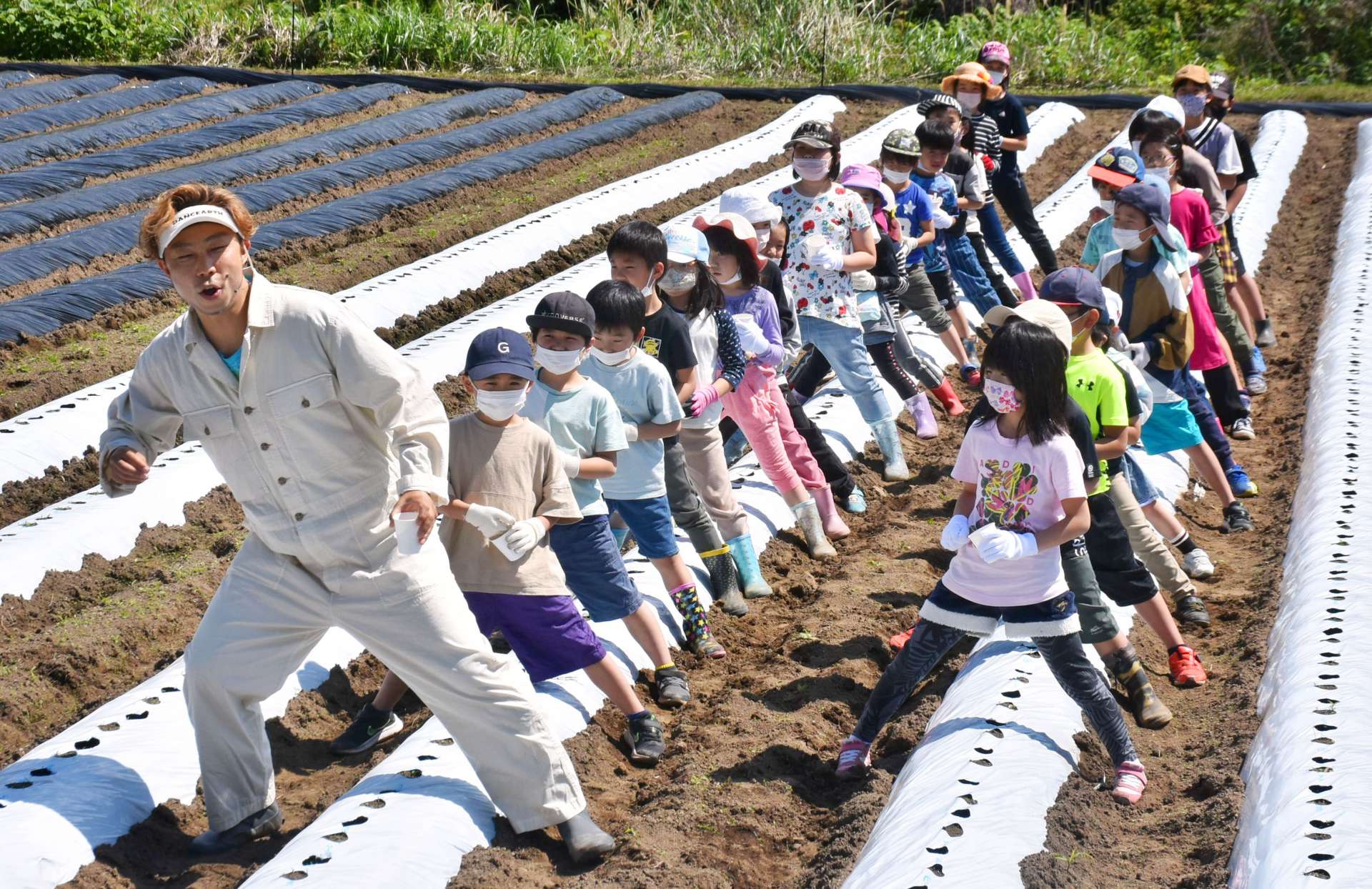 ＵＳＡさんを手本に踊りながら種をまく子どもたち