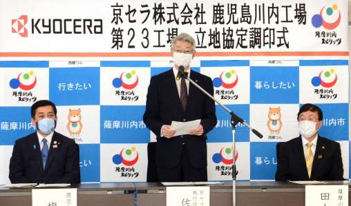 立地協定の調印を終え、あいさつする京セラの佐藤隆執行役員常務（中央）＝２０日、薩摩川内市役所