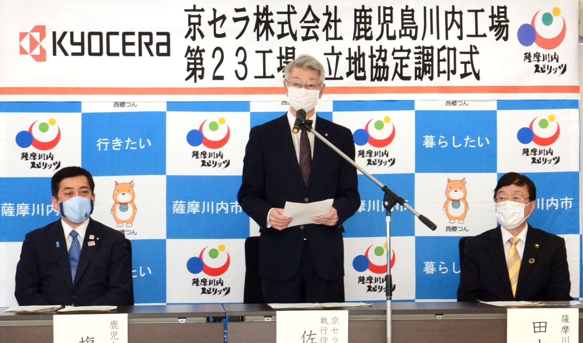 立地協定の調印を終え、あいさつする京セラの佐藤隆執行役員常務（中央）＝２０日、薩摩川内市役所