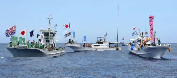 北緯２７度線付近の海上集会でバンザイをする与論町（右）と沖縄県国頭村の代表＝４月２８日、与論町の南方沖