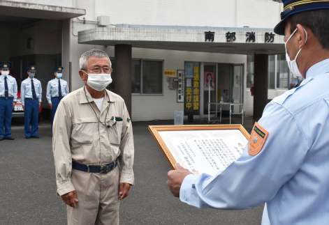 消防署長から感謝状を受ける皆倉自治会の諏訪原美義会長（左）＝錦江町城元