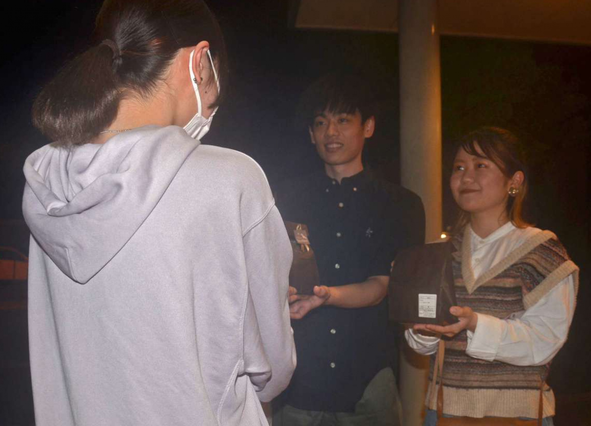 ５月、女子高校生からお礼の品を受け取る岩拓夢さん（左）と伊東未来さん