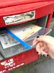 同僚記者が投函する投票用紙の入った封筒＝６月２５日、鹿児島市