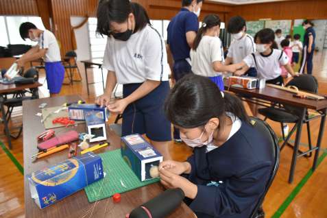 ジャンボタニシ駆除のわなを作る児童＝出水市荘の蕨島小学校