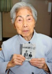 戦前は生家近くの上之原水源地でよく花見を楽しんだ。当時、末弟の義彦さんと並んで撮った写真を手にする松山シヅさん