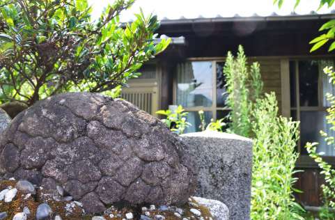 屋久島町の宮之浦集落で、民家の門柱の横に飾られる「亀石」