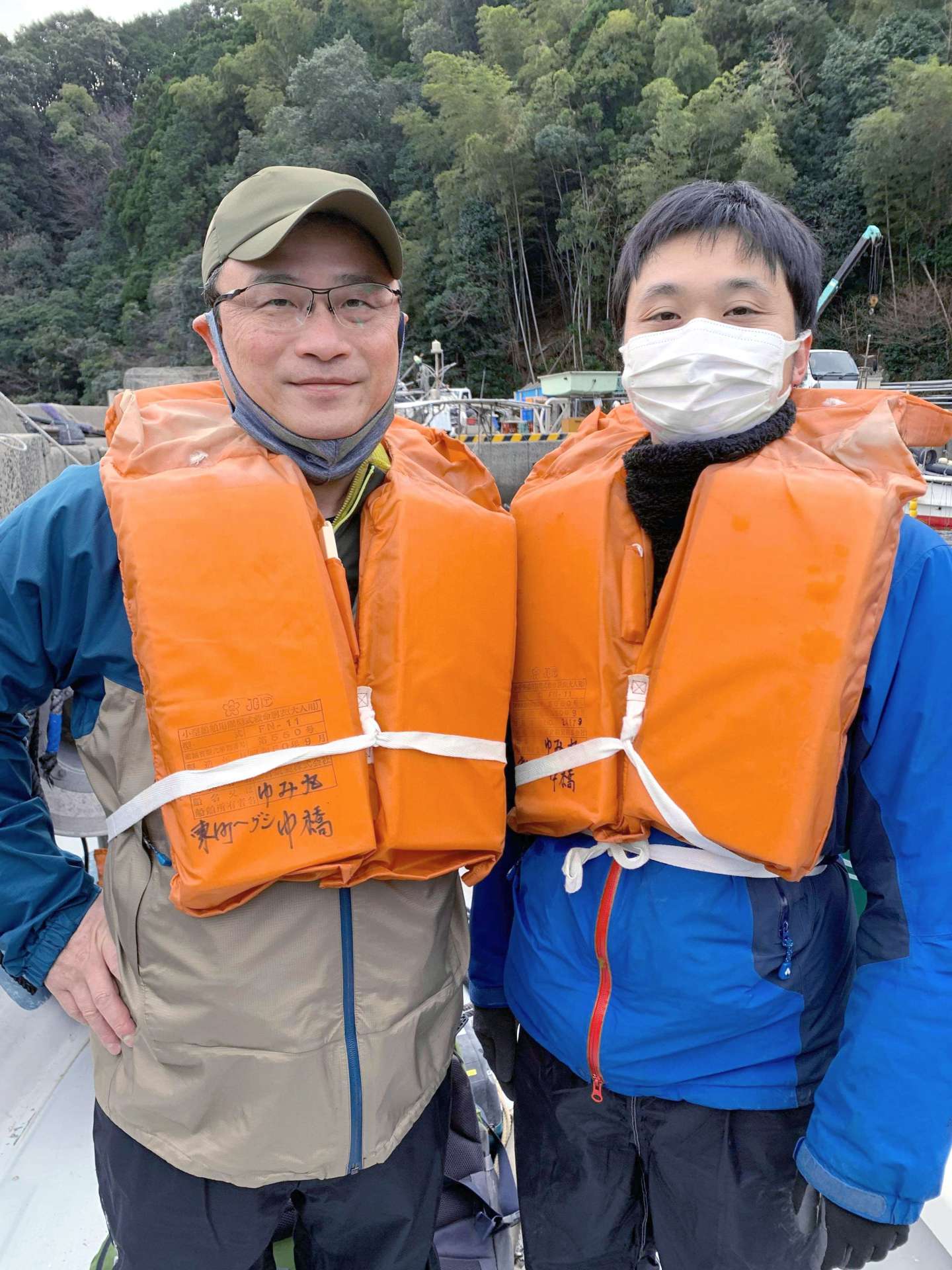 漁船に乗り込み、獅子島へ恐竜化石調査に向かう筆者（左）と中島保寿さん＝２０２１年１１月