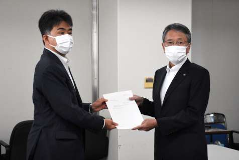 防衛省地方協力局の田中利則次長（左）から回答書を受け取る西之表市の八板俊輔市長＝同市役所