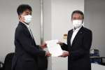 防衛省地方協力局の田中利則次長（左）から回答書を受け取る西之表市の八板俊輔市長＝同市役所