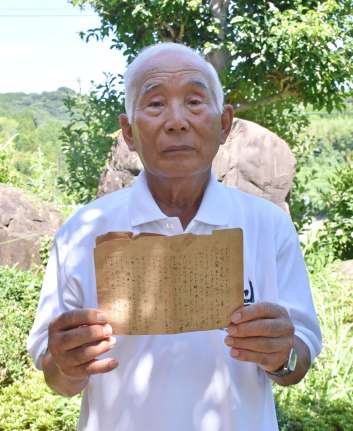 亡き姉が記した手記を手にする別府俊明さん＝薩摩川内市水引町