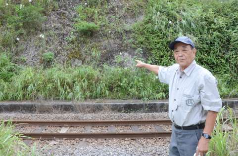 ＪＲ日豊線沿いの防空壕の入口跡を指さす若宮耕三さん＝鹿児島市清水町