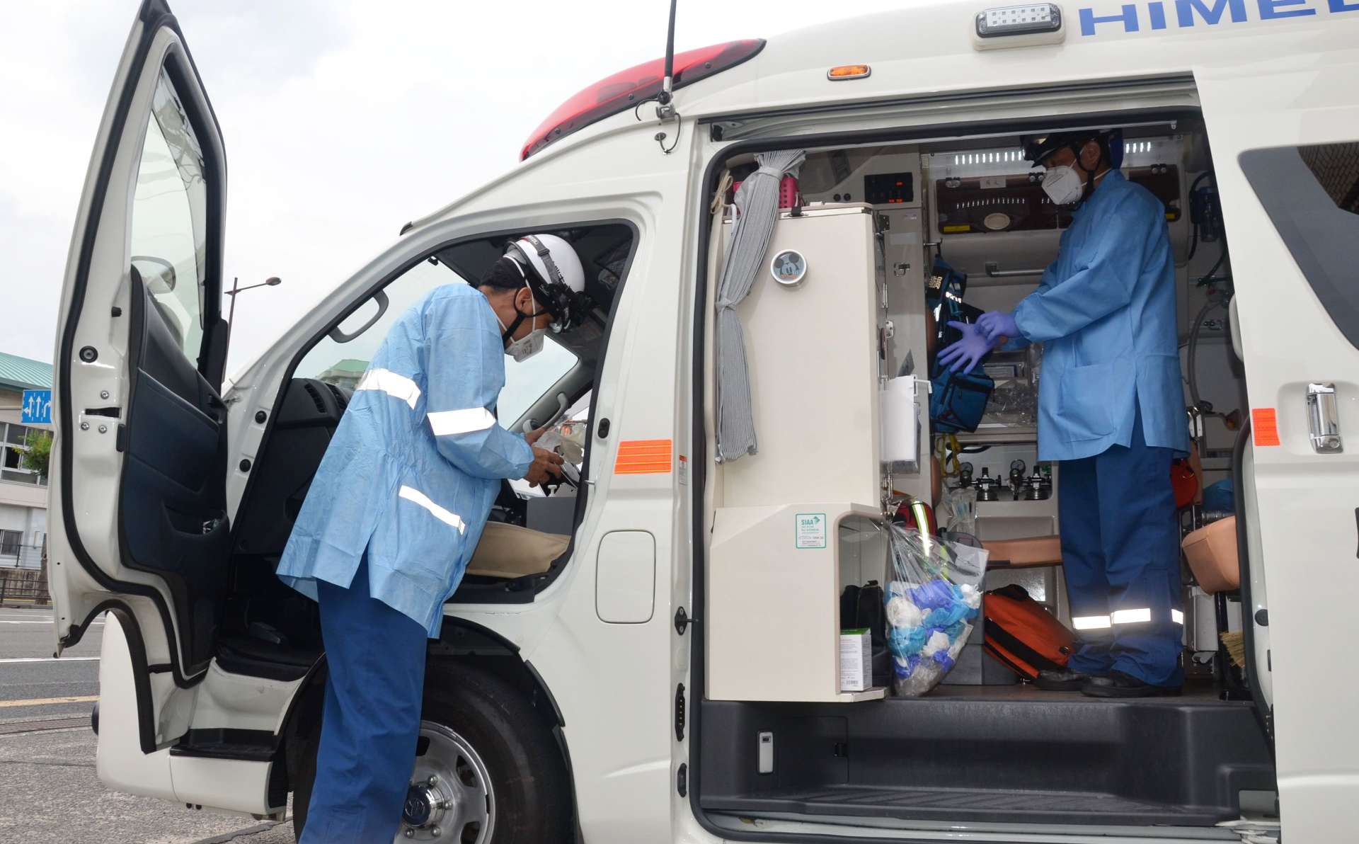感染防止衣を身にまとい、救急車に乗り込む救急隊員＝１７日午後、鹿児島市天保山町の鹿児島市消防局中央消防署中央本署