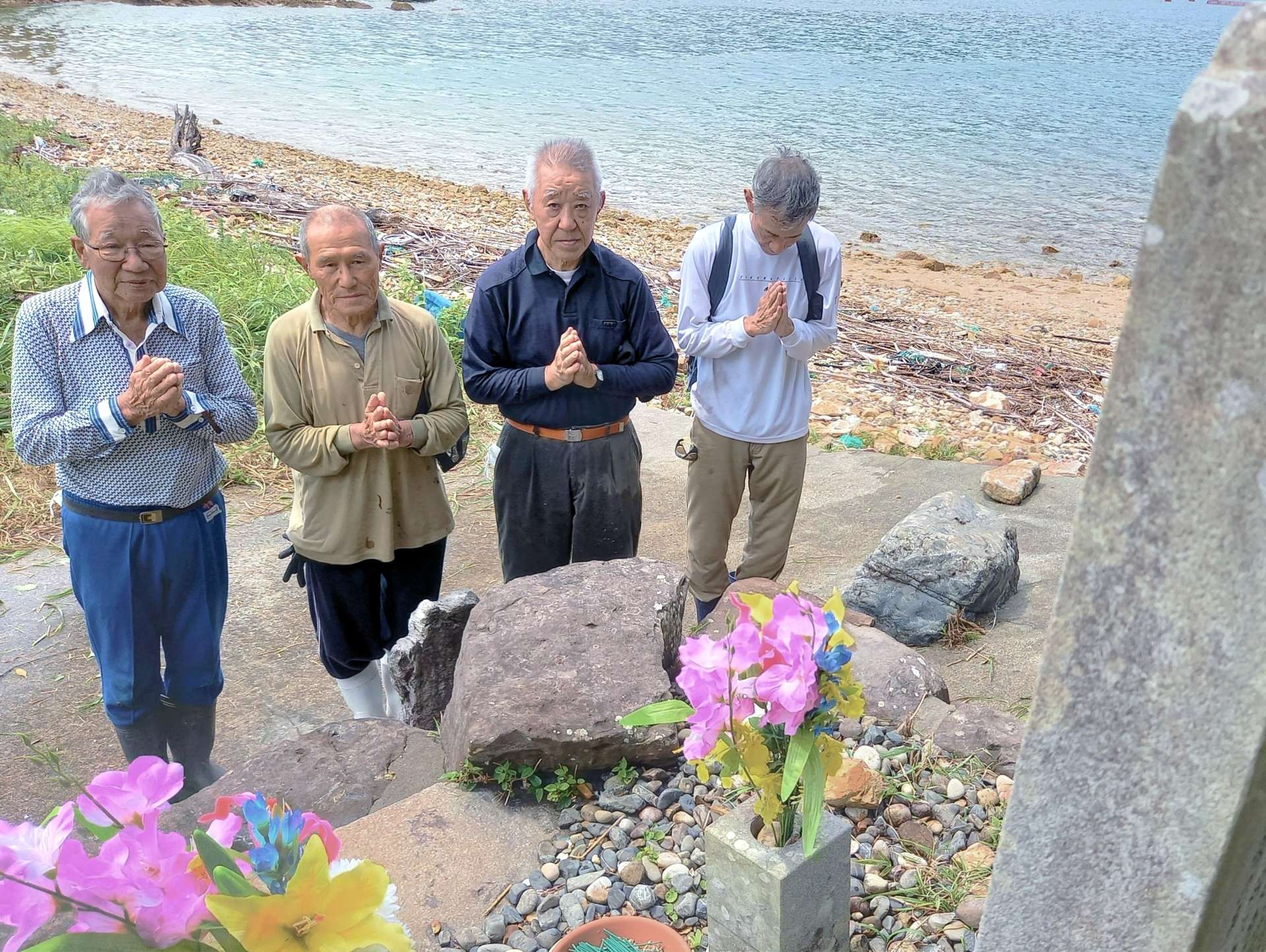 震洋隊の碑に手を合わせる住民＝１９日、南さつま市笠沙町片浦