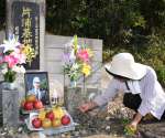 ２０１５年に亡くなった有田牧夫部隊長の遺影が掲げられた慰霊碑＝２０１６年、南さつま市笠沙町片浦