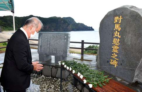 慰霊碑に花を供え、犠牲者の冥福を祈る参列者＝２７日、宇検村宇検