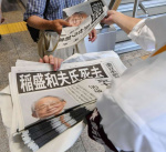 稲盛和夫さんの死去を報じる号外を受け取る人＝３０日、鹿児島市中央町