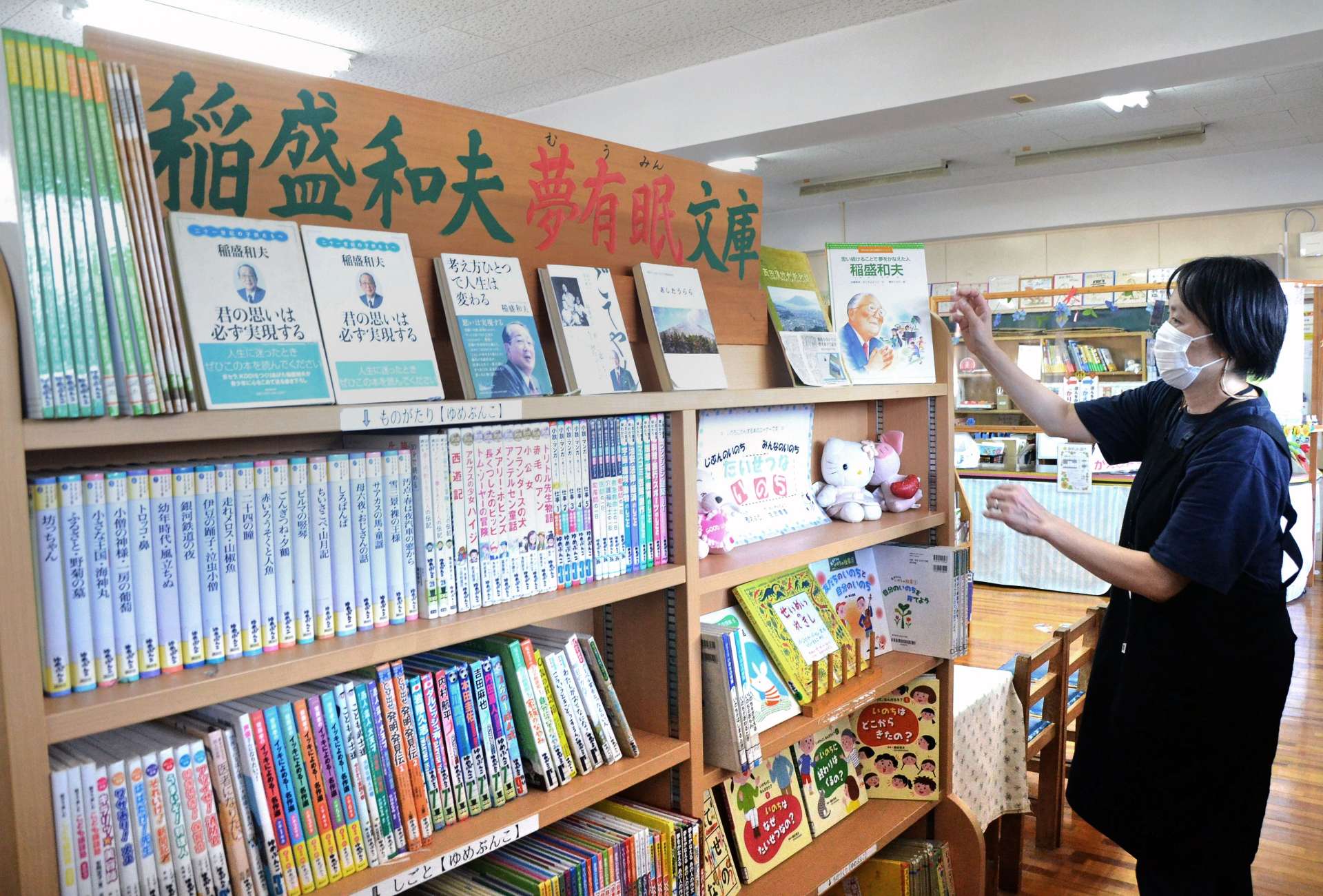 伝記や職業紹介など稲盛和夫さんの寄付でそろえた本が並ぶコーナー＝３０日、鹿児島市の西田小学校